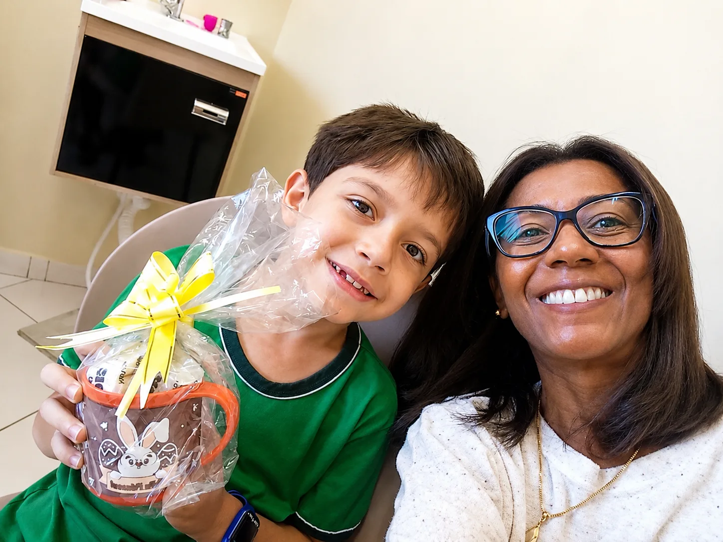 Elisangela e paciente sorrindo com lembrancinha de Páscoa